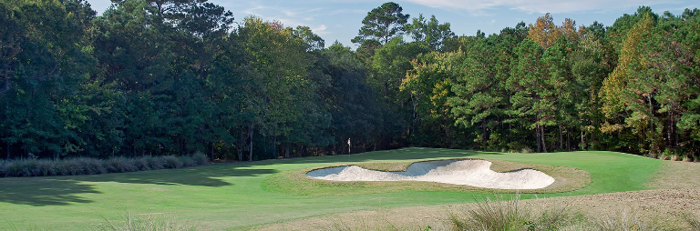 Image: Distant view of green with ominous sand trap keeping watch