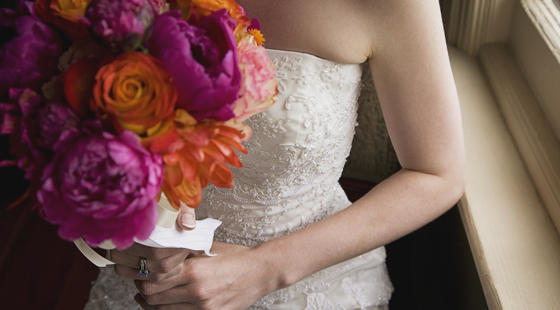 Bride with flowers in hands clutched to chest Image: Bride with flowers in hands clutched to chest