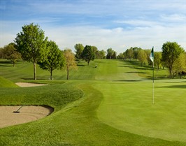 Image; Lexington Country Club green with sand traps on left, looking back a long fairway.