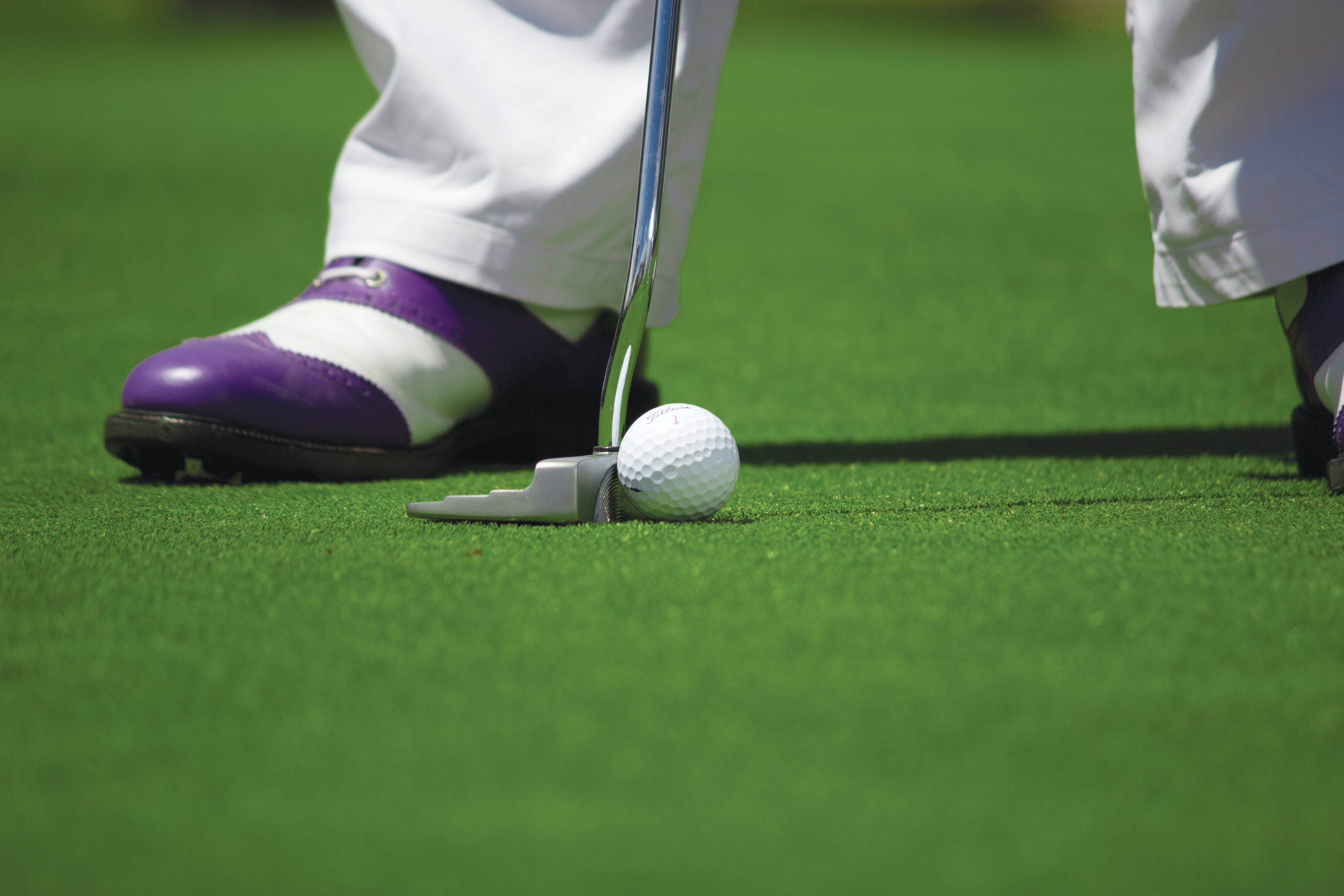 Image: Man putting with purple shoes