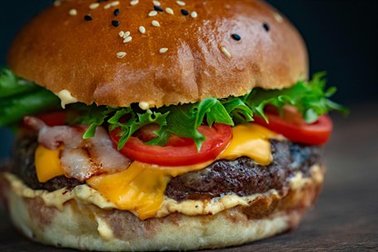 Image: Burger with cheese, lettuce and tomato in bun